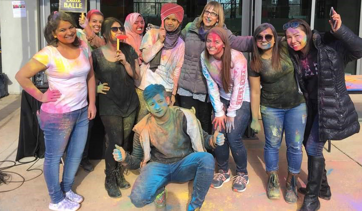 students covered in colorful powder at a holi festival at catholic university